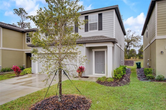 view of property with a front yard and a garage