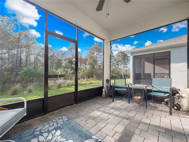 unfurnished sunroom featuring ceiling fan and a wealth of natural light