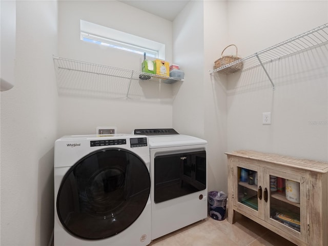 laundry area with washer and clothes dryer and light tile floors