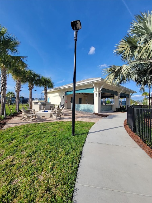 view of property's community featuring a yard and a patio area