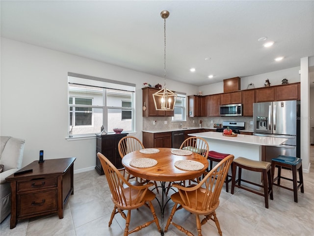 dining space featuring a healthy amount of sunlight, sink, and light tile flooring