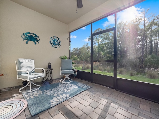 unfurnished sunroom with ceiling fan