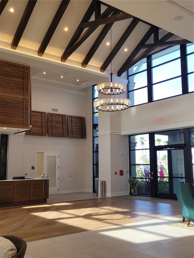 interior space featuring french doors, beamed ceiling, tile floors, a chandelier, and high vaulted ceiling