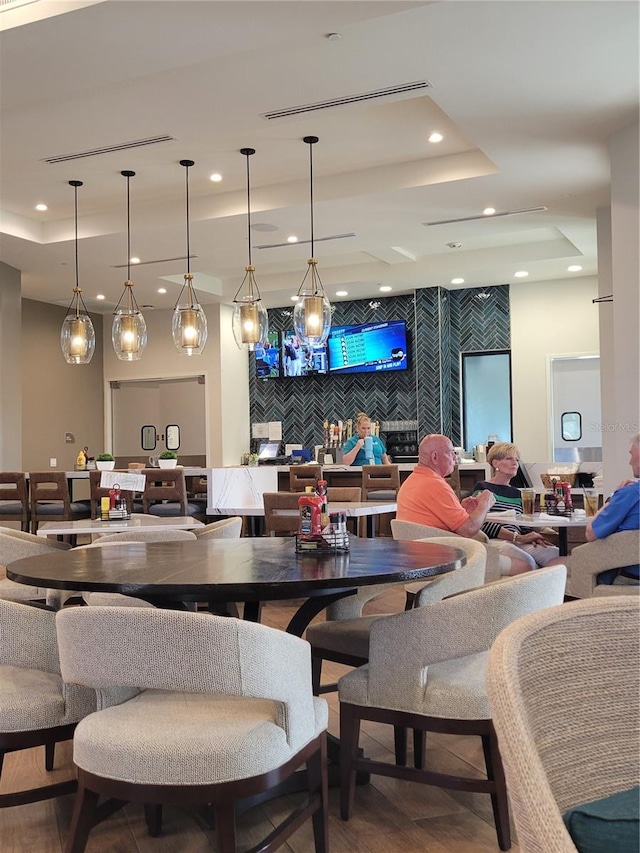 dining space with a tray ceiling and wood-type flooring