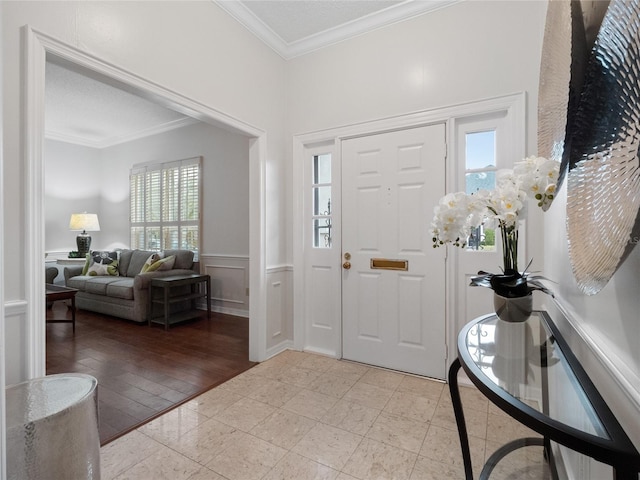 foyer with crown molding and light tile flooring