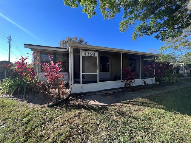 view of front of property with a sunroom and a front lawn