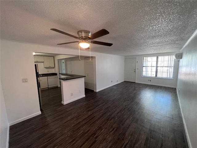 empty room featuring dark wood-type flooring, a textured ceiling, and ceiling fan