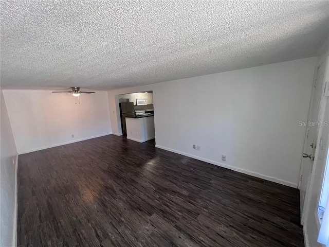 empty room featuring dark wood-type flooring, ceiling fan, and a textured ceiling