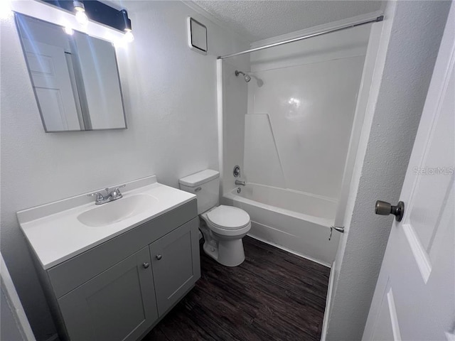 full bathroom with toilet, vanity with extensive cabinet space, hardwood / wood-style floors, shower / washtub combination, and a textured ceiling