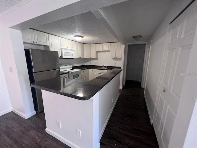 kitchen with white appliances, white cabinets, a textured ceiling, and dark hardwood / wood-style floors