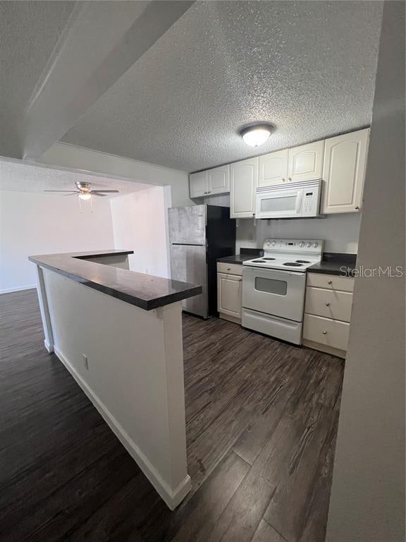 kitchen featuring dark hardwood / wood-style floors, white appliances, ceiling fan, a textured ceiling, and white cabinetry