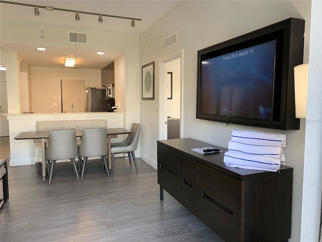 interior space with hardwood / wood-style floors and track lighting