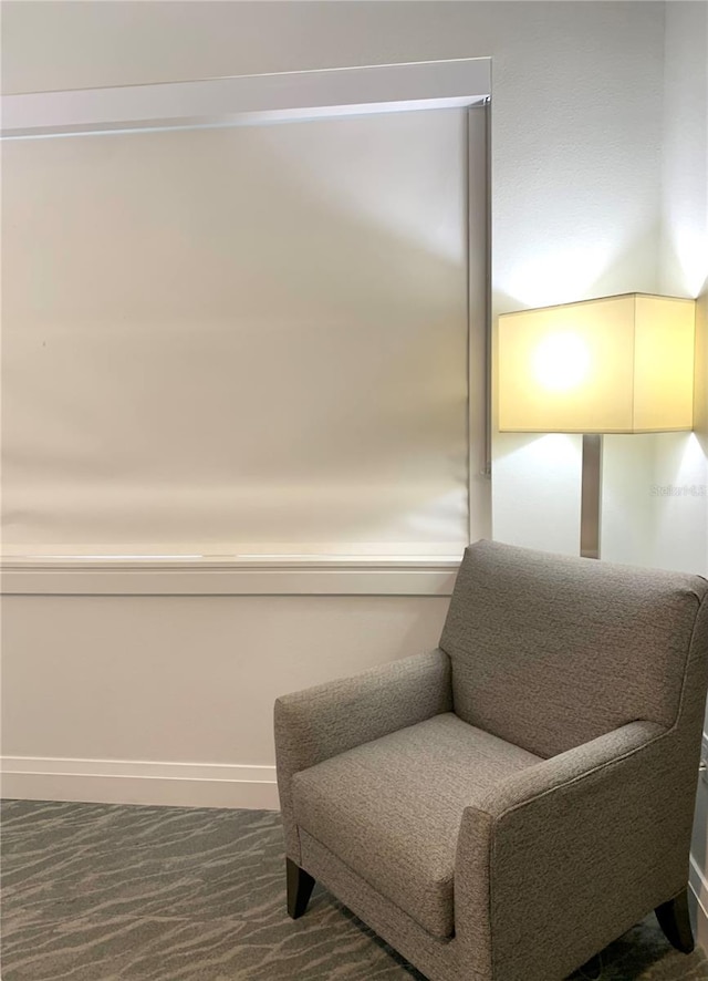 sitting room featuring dark carpet