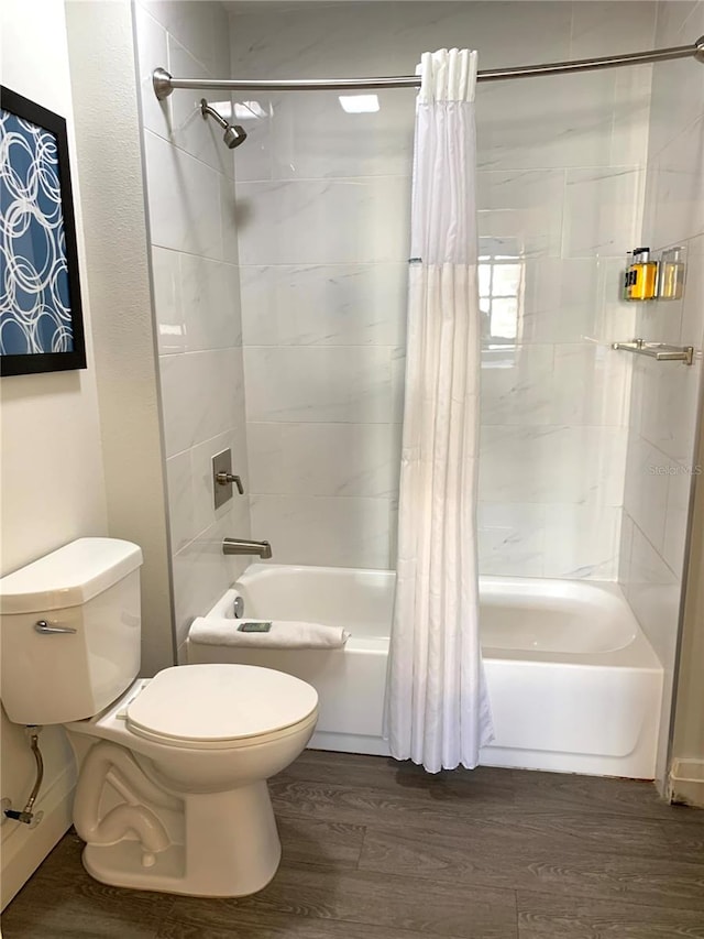 bathroom with hardwood / wood-style floors, toilet, and shower / tub combo with curtain