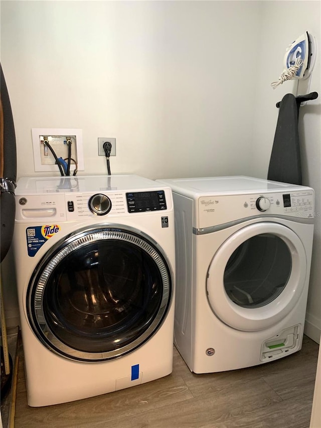 laundry area featuring washer hookup, electric dryer hookup, independent washer and dryer, and hardwood / wood-style flooring