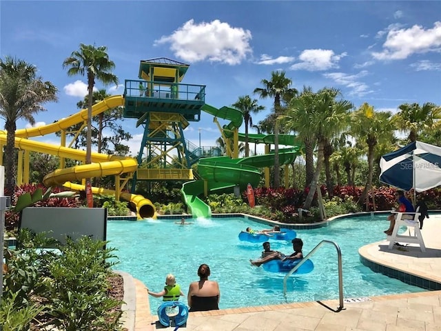 view of pool featuring a water slide and a playground