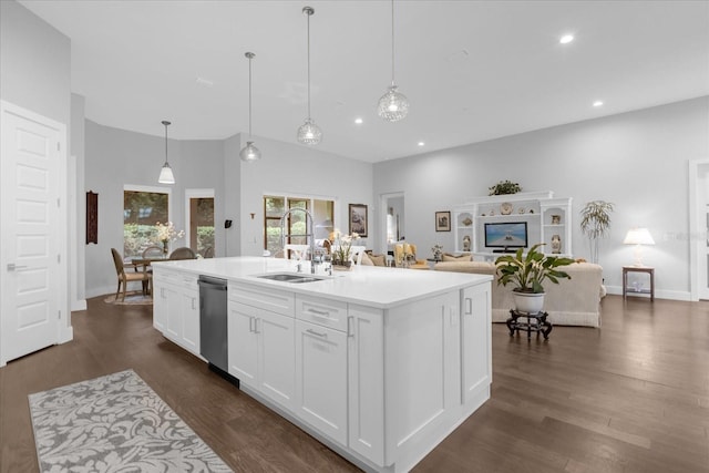 kitchen featuring dishwasher, decorative light fixtures, white cabinetry, an island with sink, and sink