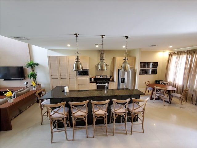 kitchen featuring light tile flooring, a kitchen breakfast bar, decorative light fixtures, and appliances with stainless steel finishes