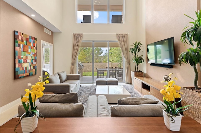 living room with hardwood / wood-style flooring and a towering ceiling