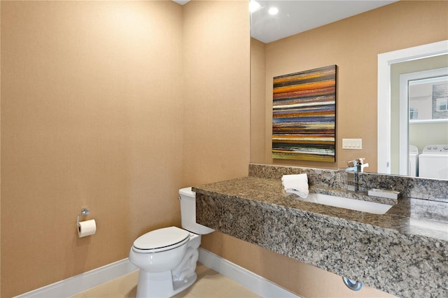 bathroom featuring oversized vanity, toilet, washer and dryer, and tile flooring