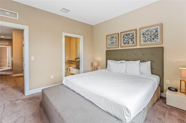 bedroom with light carpet and ensuite bath