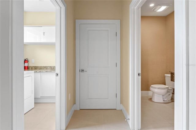 hall with washer / dryer and light tile flooring