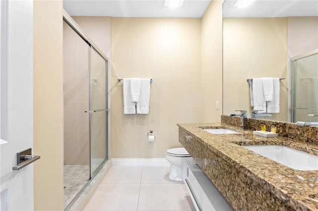 bathroom with double sink, a shower with door, tile flooring, toilet, and oversized vanity