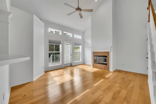 unfurnished living room with ceiling fan, light hardwood / wood-style floors, and high vaulted ceiling