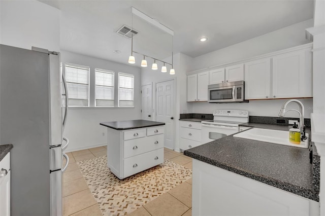 kitchen featuring white cabinets, light tile patterned floors, decorative light fixtures, a kitchen island, and stainless steel appliances