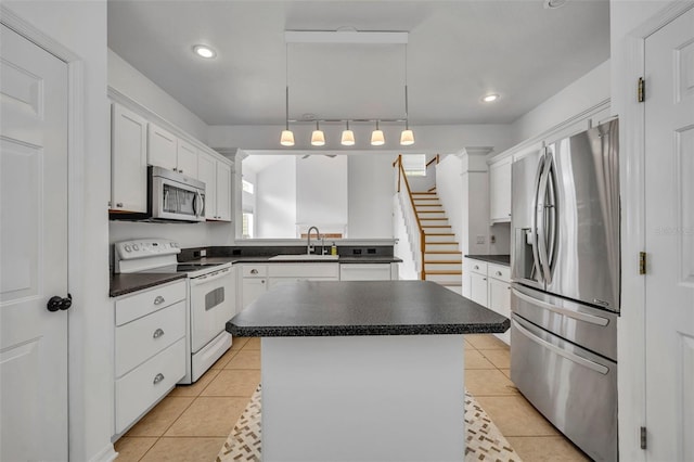 kitchen with pendant lighting, light tile patterned floors, a kitchen island, white cabinetry, and stainless steel appliances