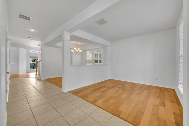 empty room featuring an inviting chandelier and light tile patterned flooring