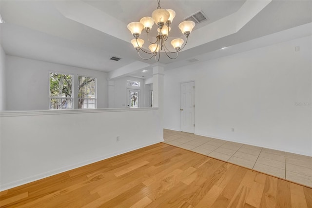 empty room with a chandelier and wood-type flooring