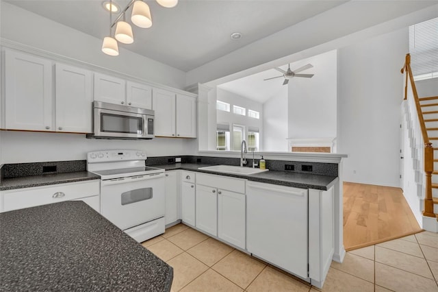 kitchen featuring white cabinets, white appliances, sink, and light tile patterned floors