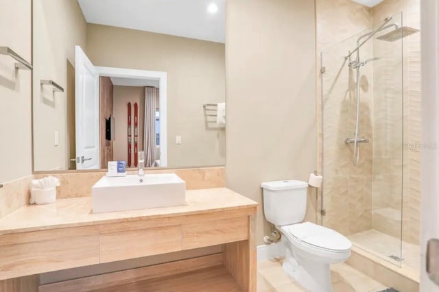 full bathroom with baseboards, toilet, a stall shower, and vanity