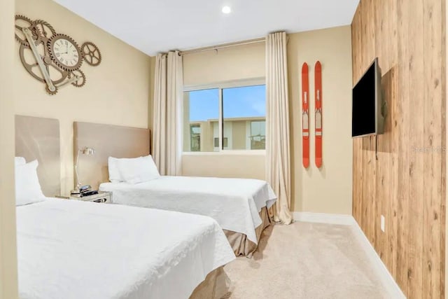 bedroom with baseboards, carpet, and wood walls