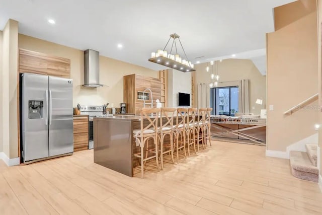 kitchen with light hardwood / wood-style flooring, stainless steel fridge, white electric range oven, pendant lighting, and wall chimney exhaust hood