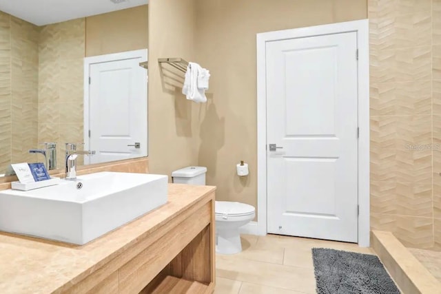 bathroom with vanity, tile patterned floors, toilet, and a tile shower