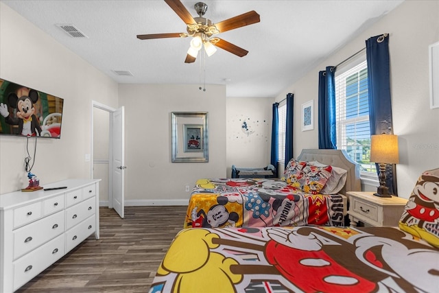 bedroom featuring multiple windows, ceiling fan, and dark hardwood / wood-style flooring