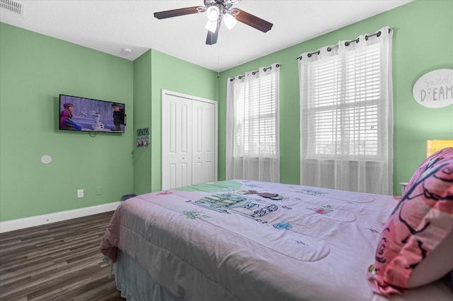 bedroom with a closet, dark hardwood / wood-style floors, and ceiling fan