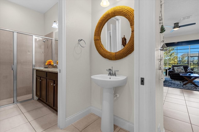 bathroom with a shower with door, tile floors, and ceiling fan