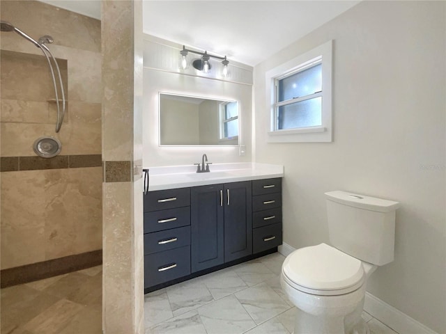 bathroom featuring vanity, toilet, and a tile shower