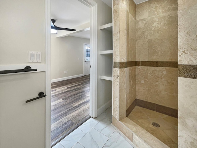 bathroom with a tile shower, ceiling fan, built in features, and hardwood / wood-style flooring