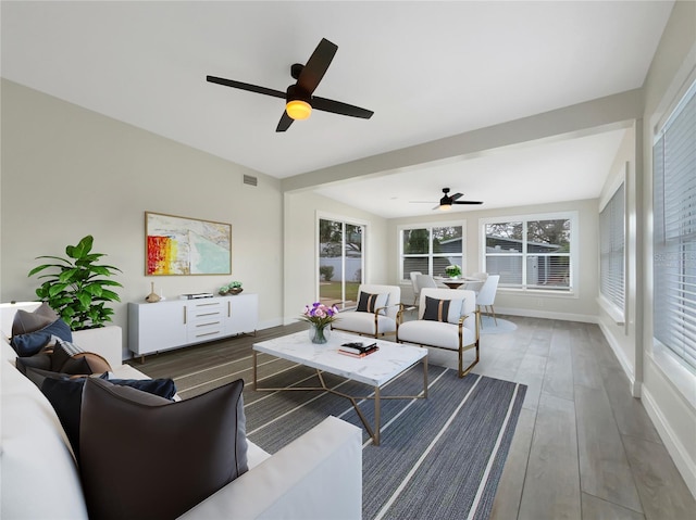 living room with dark hardwood / wood-style flooring and ceiling fan