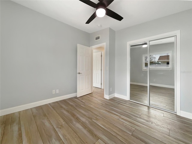 unfurnished bedroom with a closet, light hardwood / wood-style floors, and ceiling fan