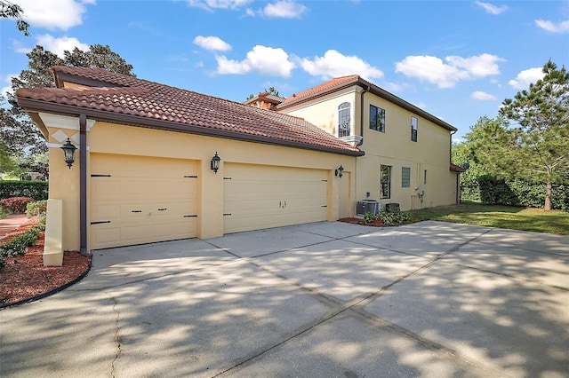 view of side of property featuring cooling unit and a garage