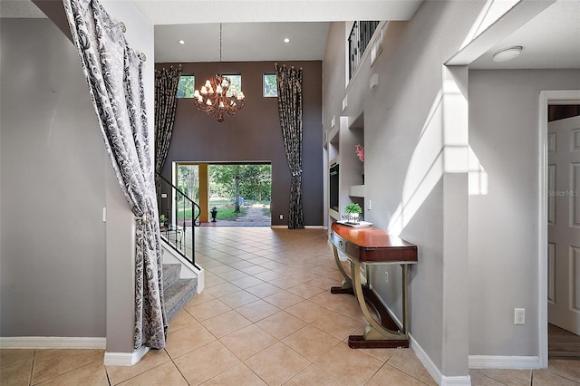 tiled foyer with a chandelier and a high ceiling