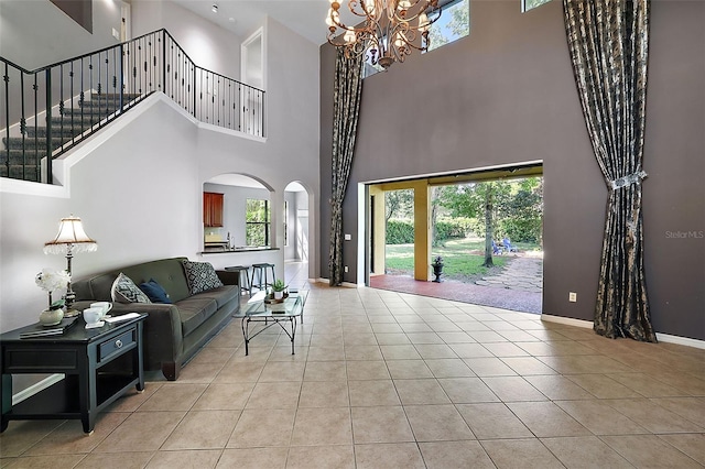 living room with light tile patterned flooring, a chandelier, and a high ceiling