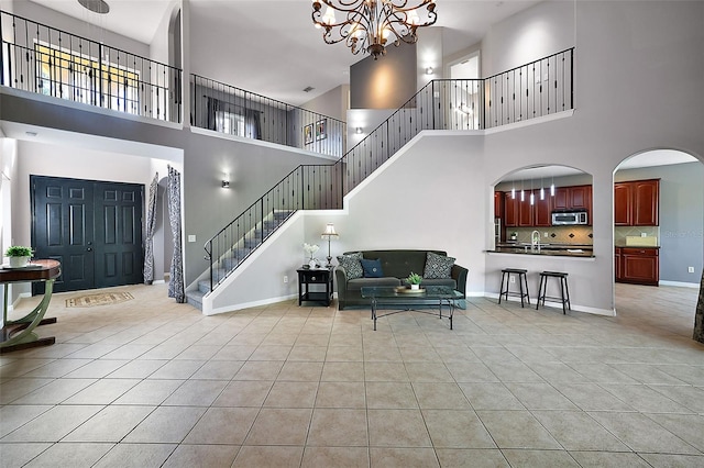 foyer with a chandelier, a high ceiling, and light tile patterned flooring