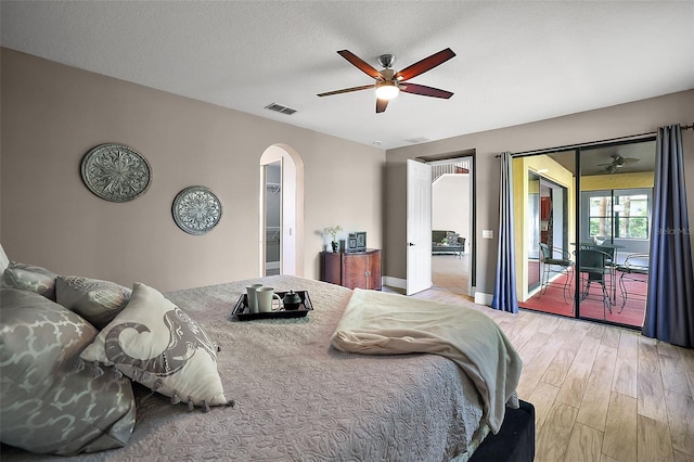 bedroom featuring ceiling fan, access to exterior, light wood-type flooring, and a textured ceiling