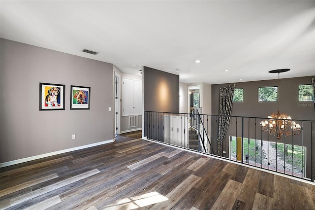 unfurnished room featuring a chandelier and hardwood / wood-style flooring